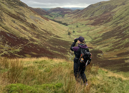 Nicky from Hiking Highs uses binoculars to spot red deer