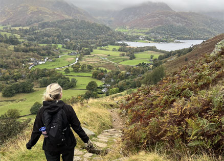 CT Staff member Alex walks down a path with Brothers Water in the background