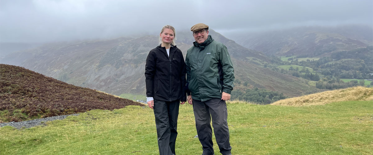 CT Staff members Alex and Rob C pose for a photo with a misty scenic backdrop