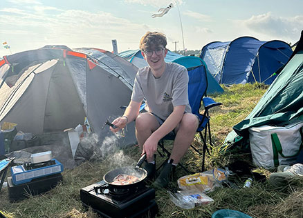 CT staff member Dan cooks up breakfast at Kendal Calling