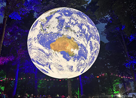 Illuminated globe in the Woodlands at Kendal Calling