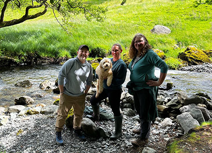 CT Staff Members Gavin and Alison with Cat from The Patterdale Estate next to a stream on the grounds