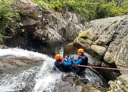 Team Members Rob Rhys and Rob Davies give a thumbs-up to the camera before going down a waterfall at Church Beck